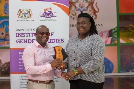 Stabroek News reporter Khadidja Ba (right) receiving her award from UG lecturer, Centre of Communication Studies Clarence Brotherson