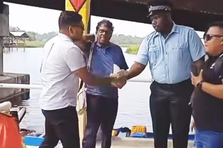Corporal Carl Sanmoogan (second from right) shaking presidential hopeful Azruddin Mohamed’s hand
