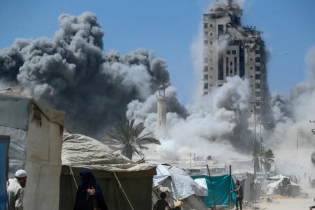 A man runs as smoke rises after a building is hit by an Israeli air strike, in Gaza City on Friday, September 5 [Mahmoud Issa/Reuters]